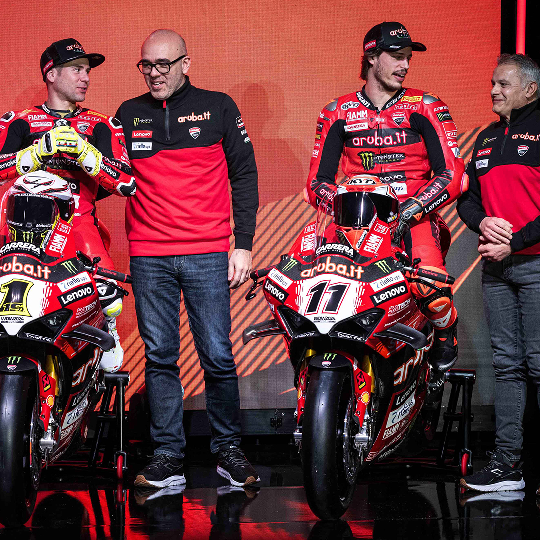 Alvaro Bautista e Nicolò Bulega sulle loro moto mentre parlano con lo staff del team Aruba.it Racing - Ducati Superbike