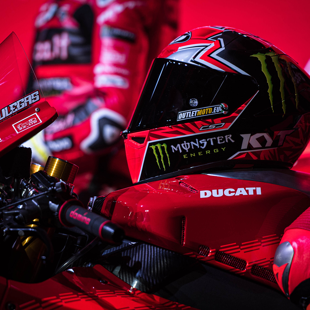 Close-up of Nicolò Bulega's helmet placed on top of his Ducati motorbike