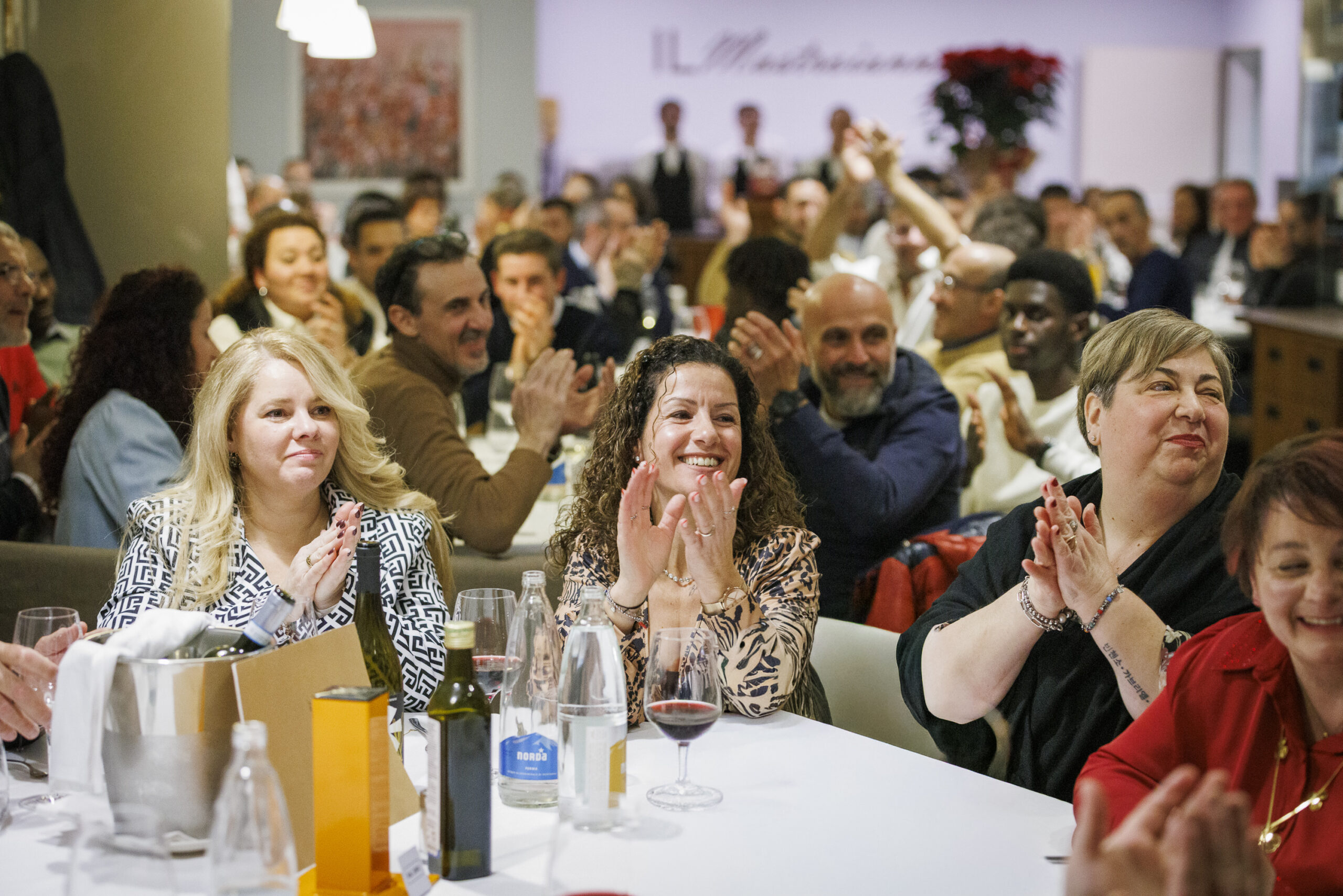 Dipendenti di Satech seduti al tavolo e in posa durante una festa aziendale, in un momento conviviale dell’evento.
