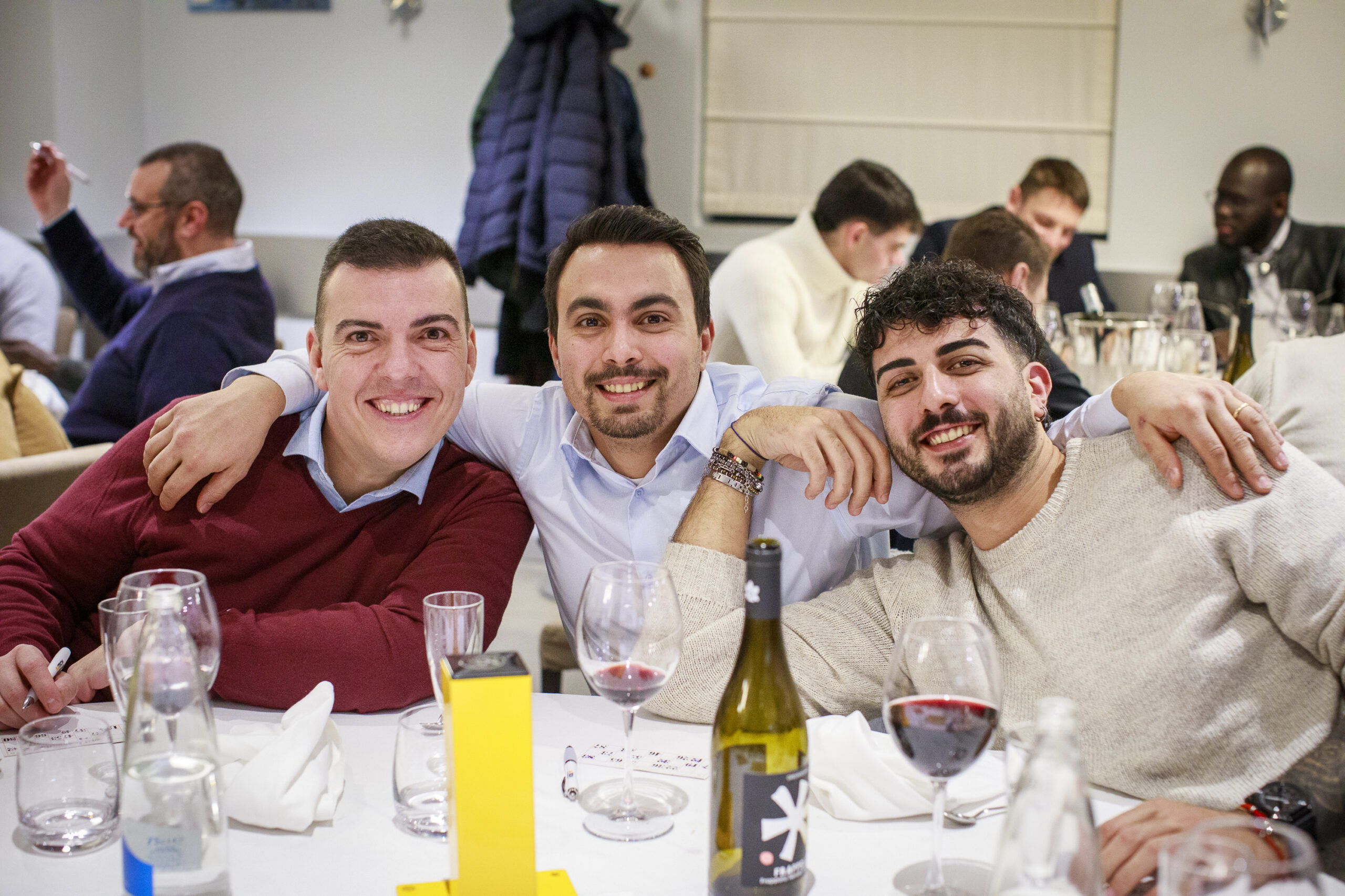 Dipendenti di Satech seduti al tavolo e in posa durante una festa aziendale, in un momento conviviale dell’evento.