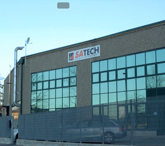 Exterior view of the Satech headquarters in Merate, with industrial building, glass façades and company logo signage.