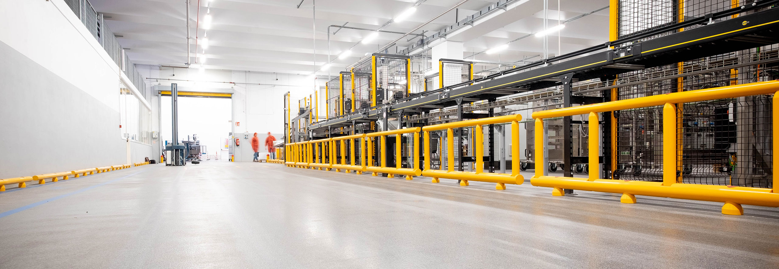Vista prospettica di delimitatori bifilari della linea Satech EASYFIT davanti a macchinario industriale