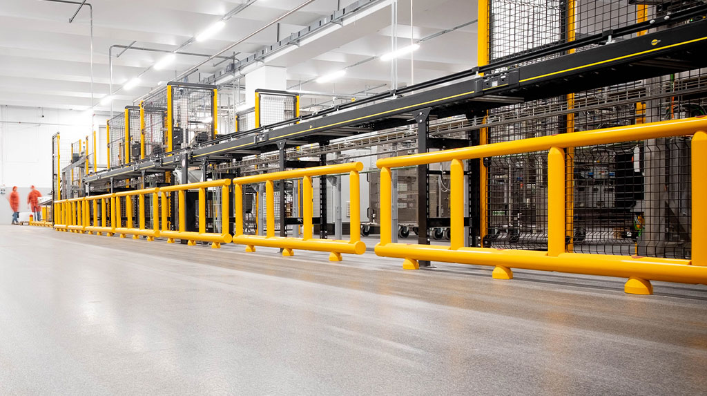 Vista prospettica di delimitatori bifilari della linea Satech EASYFIT davanti a macchinario industriale